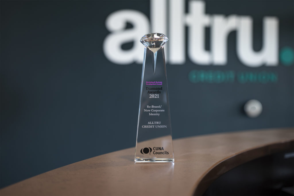 CUNA Diamond Award sitting on the counter at the St. Charles branch with alltru logo on the wall in the blurred background