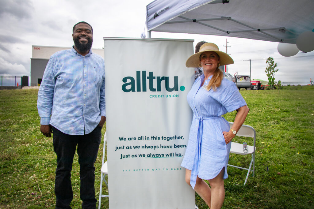 Kenneth Paige and Tracy Verner stand next to an Alltru sign at the future Florissant branch location