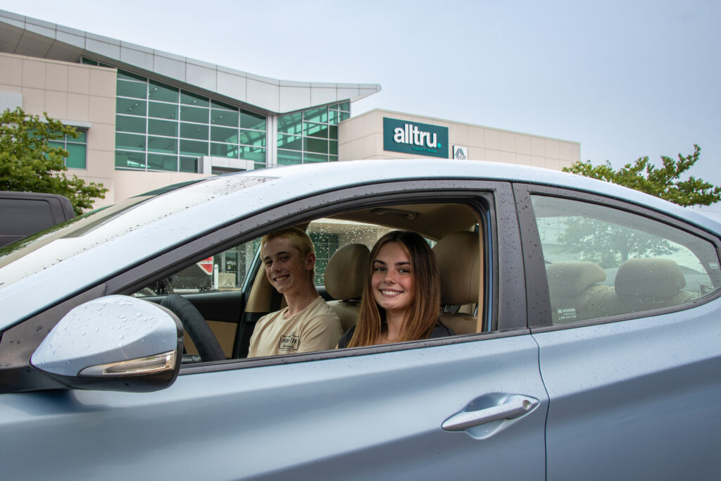 Two teen Alltru members inside a car