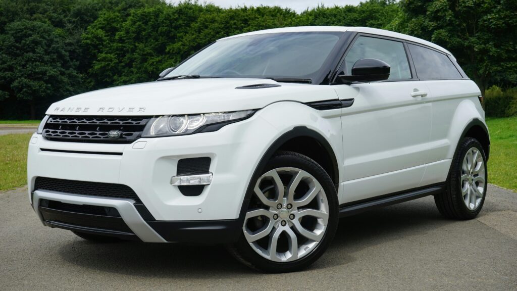 A new white Range Rover parked on a one lane road