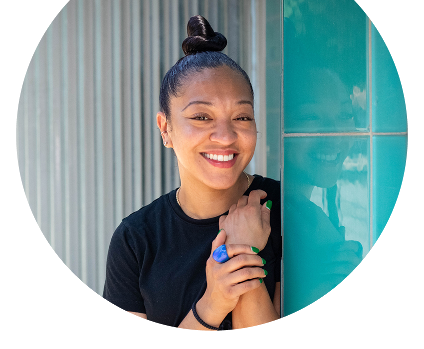 Rewards Checking | Alltru Credit Union | St. Louis, MO A photo of Alltru member Meghan standing against a teal wall