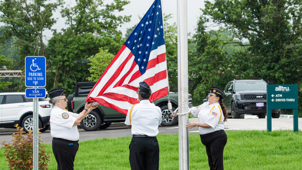 A photo of the American Flag being raised at Alltru's Florissant branch
