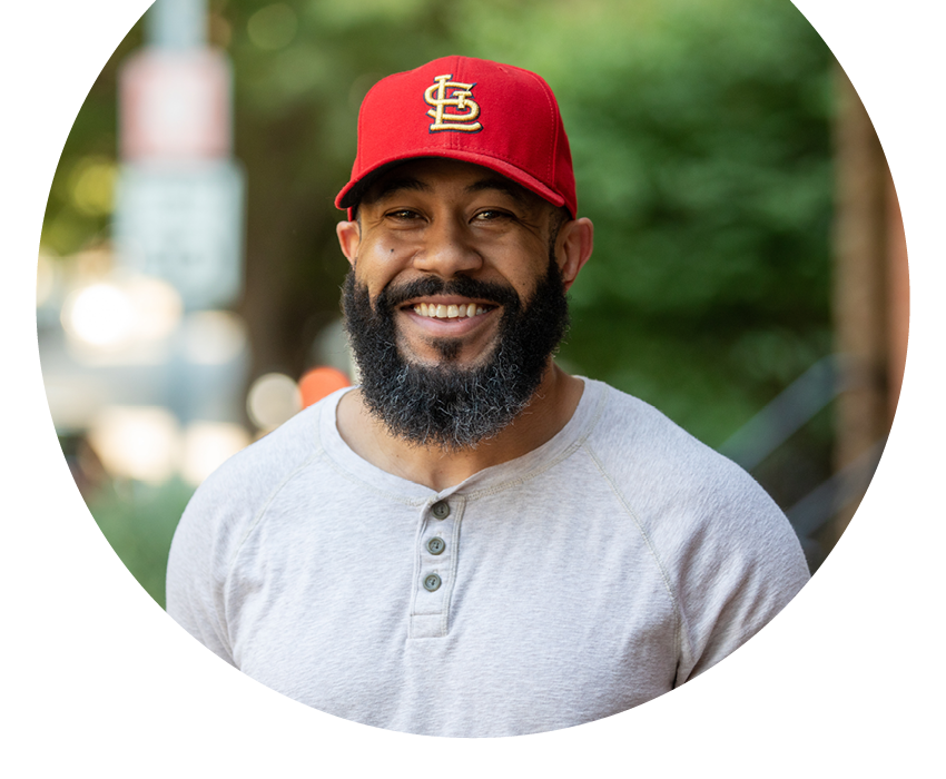 Alltru member Craig wearing a St. Louis Cardinals hat. Photo is a cut circle shape